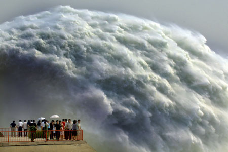 Tourists watch water flush out of the sluice of the Xiaolangdi Dam on the Yellow River in Central China's Henan Province June 18, 2006. The view attracts more than 10,000 visitors from across the country. [Xinhua]