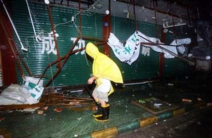 A man walks by billboards blown down by strong winds as Typhoon Saomai whips Cangnan county in east China's Zhejiang province, Thursday Aug. 10, 2006. Typhoon Saomai, the most powerful storm to hit China in decades slammed into the country's southeast coast Thursday after more than 1.3 million people were evacuated, the government's main news agency reported.(AP Photo