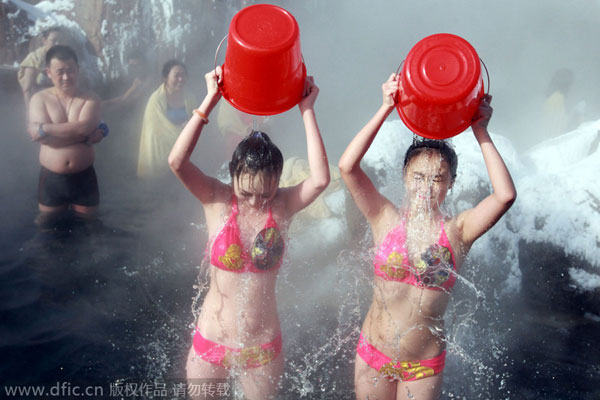 Girls in bikini pour ice in hot spring