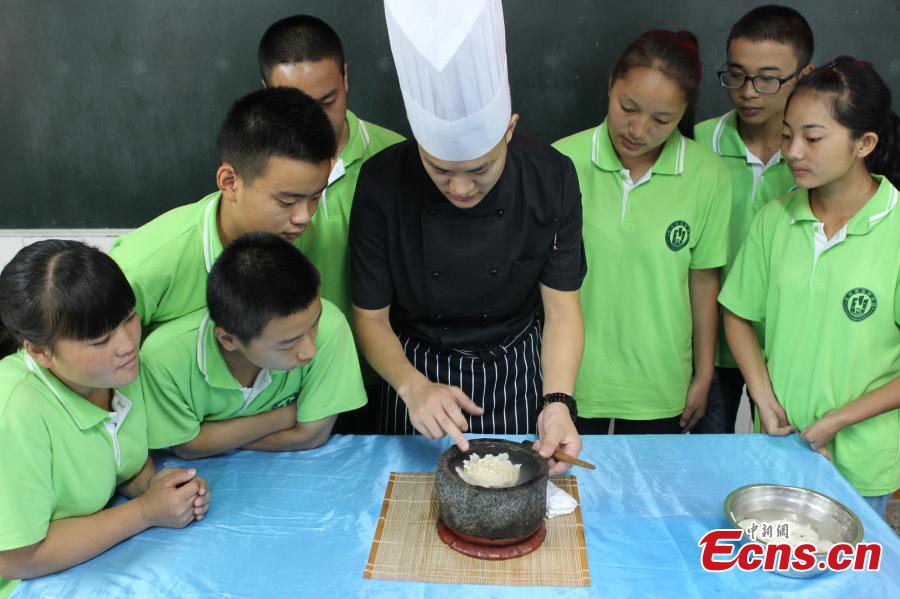 Man writes Chinese calligraphy using kitchenware