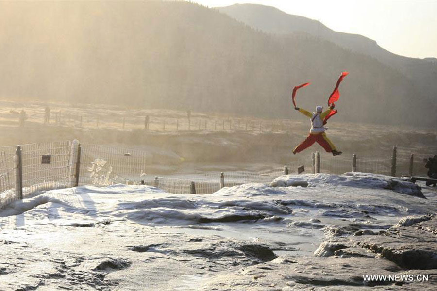 Visitors view frozen Hukou Waterfall on Yellow River