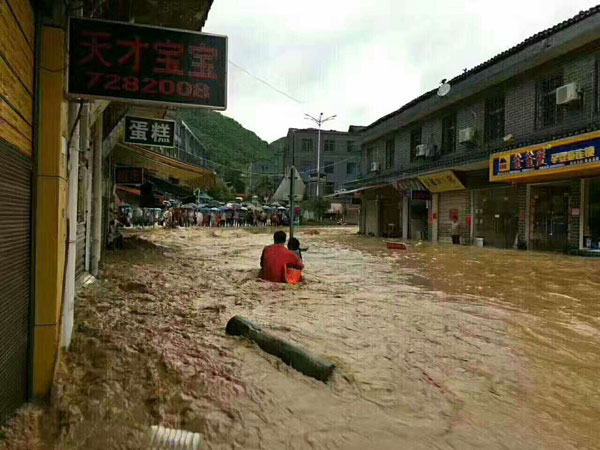 Man braves floodwaters to save shopkeeper