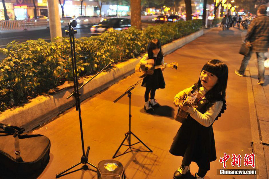 Six-year-old twin street musicians tour with their father