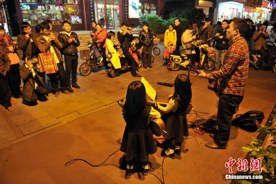 Six-year-old twin street musicians tour with their father