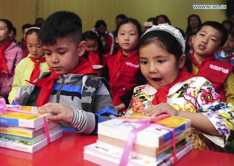 Cao Wenxuan presents books to children, Northwest China's Xinjiang