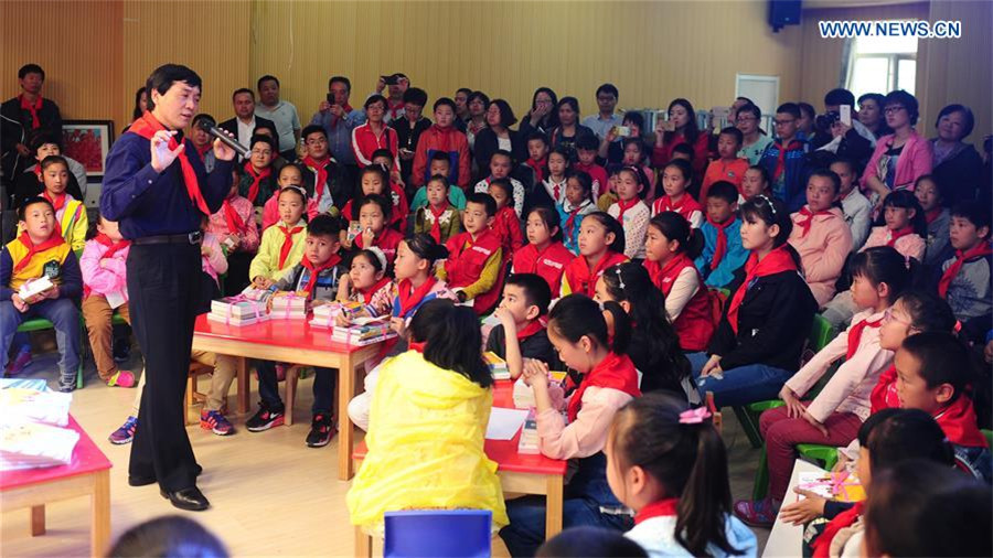 Cao Wenxuan presents books to children, Northwest China's Xinjiang