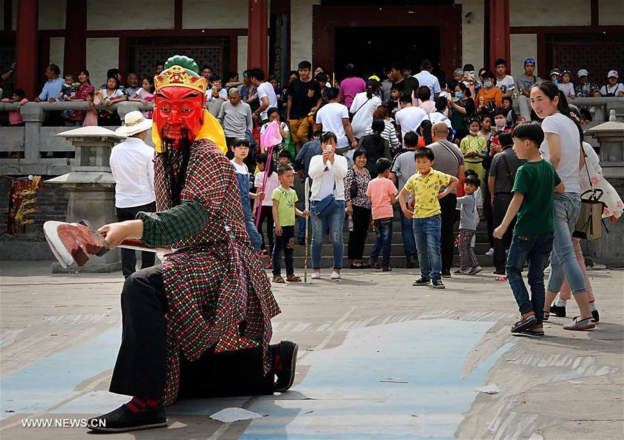 Tourists view Nuo dance at China's Yongcheng