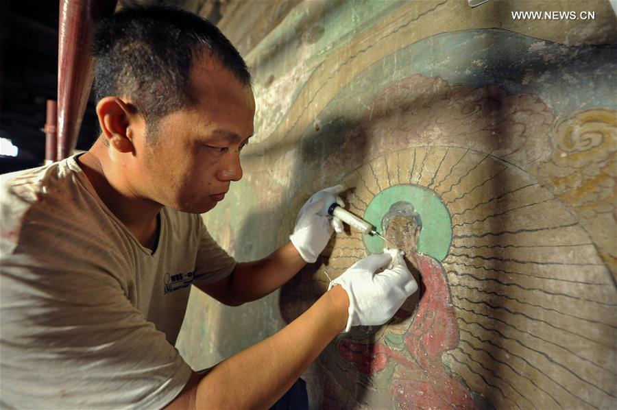 Experts restore ancient murals at temple in N China