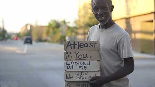 美國“犀利哥”自制翻牌標語走紅網(wǎng)絡(luò) Sign him up! Homeless man uses empty beer boxes in make-shift board that FLIPS between begging messages