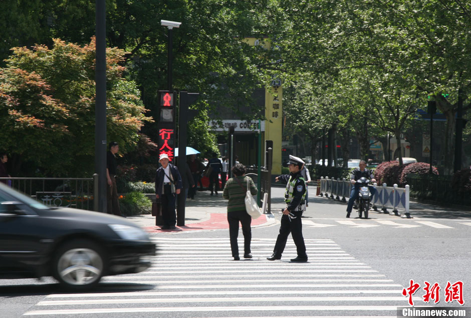 杭州新招治“中國式過馬路” 路邊擺屏幕“現(xiàn)場直播”