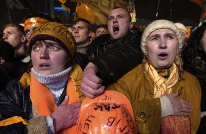 Demonstrators gathered to protest alleged fraud in the presidential elections sing the Ukrainian National anthem on the main square of the Ukrainian capital Kiev, Wednesday, Nov. 24, 2004, for a third consecutive day. The Central Election Commission on Wednesday declared Prime Minister Viktor Yanukovych the winner of Ukraine's presidential election, sharpening a crisis sparked by the opposition candidate Viktor Yushchenko's allegations that the vote was brazenly fraudulent. [AP]