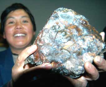 A woman shows a piece of meteorite dropped onto the earth after the nightly explosion in Gansu Province Saturday night. ufo [newsphoto]