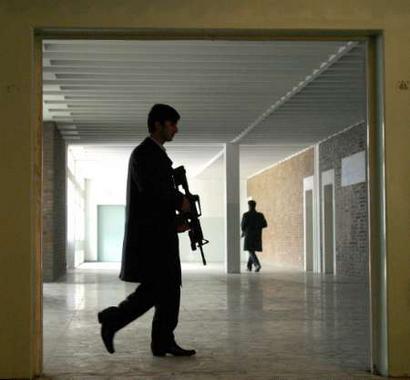 Security guards for Afghan President Hamid Kharzai guard a school hosting a ceremony for the National Children Conference, aimed to promote better life and education conditions for Afghanistan's children, in Kabul December 14, 2004. Afghan security forces have captured the Taliban leader Mullah Mohammad Omar's personal security chief as he travelled in a van to the southern city of Kandahar, provincial officials told Reuters on Tuesday. [Reuters]