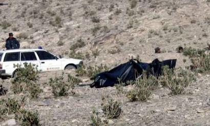 The body of a Turkish engineer (wrapped in a black sheet) lies on the ground in Chawki district of Kunar province, December 15, 2004. A Turkish engineer abducted by a militant gang in eastern Afghanistan was found dead on Wednesday. [Reuters]