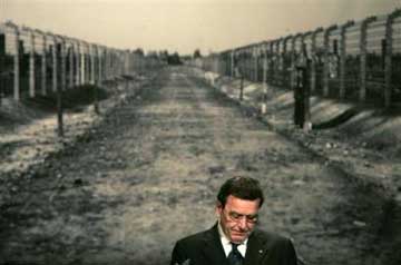 German Chancellor Gerhard Schroeder speaks in front of a photo showing a way in the Nazi concentration camp Auschwitz, during a commemoration of the International Auschwitz Committee marking the 60th Anniversary of the liberation of concentration camps Tuesday, Jan. 25, 2005. The International Auschwitz Committee is an organisation of survivors of the Nazi concentration camp Auschwitz-Birkenau. (AP 