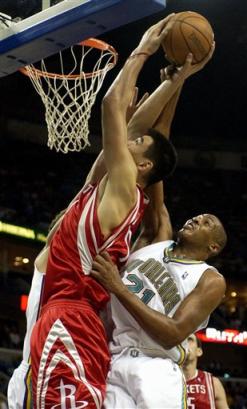 Houston Rockets center Yao Ming (11) goes up for a shot but is fouled by New Orleans Hornets center Jamaal Magloire (21) during the second half in New Orleans on Friday, March 25, 2005. The Rockets defeated the Hornets, 81-68. [AP]