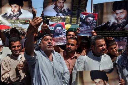 Iraqis wave pictures of Shiite cleric Muqtada al-Sadr during a rally after Friday prayers in the Sadr City section of Baghdad, Iraq Friday, April 8, 2005. al-Sadr, who led uprisings against the U.S.-led coalition last year, called on his supporters to stage a mass protest at Firdos Square in Baghdad Saturday, where jubilant demonstrators pulled down a statue of Saddam Hussein two years earlier, marking the beginning of a U.S.-led occupation of the country. Shiite and Sunni religious asked their supporters to hold demonstrations Saturday to demand that U.S.-led troops leave.(AP Photo/Karim Kadim)