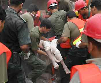 Pakistani rescue workers remove a body after a blast in Lahore May 3, 2005. At least 16 people were killed and about a dozen injured in Pakistan's eastern city of Lahore on Tuesday when three buildings collapsed after gas cylinders exploded, police and witnesses said. REUTERS