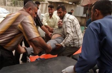 An injured Iraqi man is transported to a local hospital after a car bomb exploded near a market in eastern Baghdad, Iraq, Thursday, May 12, 2005, killing at least six people and wounding 13, police said. (AP