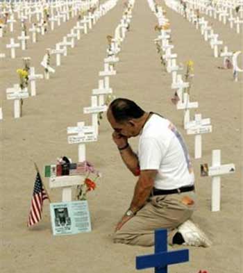 Fernando Suarez del Solar pays his Memorial Day respects at the cross representing his son, who was killed in Iraq in 2004, at the Arlington West memorial in Santa Monica, Calif., Monday, May 30, 2005. Each cross in the memorial, erected by Veterans for Peace, represents a U.S. casualty killed in Iraq. (AP