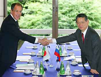 Russian Foreign Minister Sergei Lavrov (L) shakes hands with his Japanese counterpart Nobutaka Machimura over the table at the start of talks in Tokyo May 31, 2005. Lavrov arrived in Tokyo on Tuesday for a two-day visit to discuss with Japanese officials a decades-old territorial row and the timing of a visit to Japan by President Vladimir Putin. [Reuters]