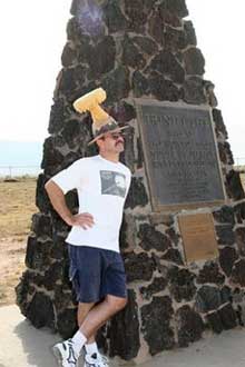 D.C. Moons from Detroit, wearing a hat shaped like a mushroom cloud thet he made out of foam, poses for a friend beside the Trinity Site moument, where the first atomic bomb was tested 60 years ago, at White Sands Missile Range, N.M., Saturday July. 16, 2005. (AP 