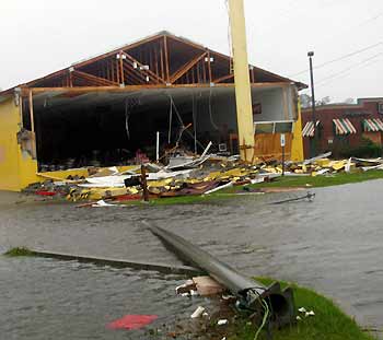 A western clothing store (L) is badly damaged while a restaurant next door remains intact after Hurricane Katrina hit Gulfport, Mississippi August 29, 2005. 