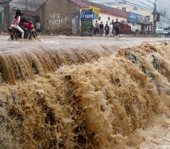 A motorcyclist rides on a flooded street in Jinan, East China's Shandong Province September 19, 2005. The city embraced a heavy rainfall from Sunday evening to Monday morning. [Xinhua]