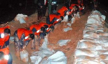 Chinese soldiers move sandbags to strengthen a dyke upon the approach of Typhoon Longwang in Xiamen, east China's Fujian province, October 2, 2005.