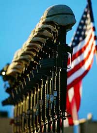 A row of U.S. Army helmets are perched on M-16 rifles during a memorial at Al Asad air base for the 15 victims of a Chinook helicopter which was shot down by insurgents in this November 6, 2003 file photo. As the U.S. military death toll in Iraq reached 2,000, U.S. President George W. Bush said on October 25, 2005 that the war will require more time and sacrifice and rejected calls for a U.S. pullout.