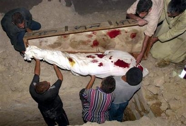 Iraqi men bury a dead relative in this Friday, Oct. 22, 2004 file photo in Fallujah, west of Baghdad, Iraq after a U.S. air strike.