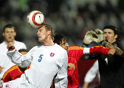 Slovakia's soccer player Jan Durica (L) heads the ball against Spain's soccer player Raul (C) and Slovakia's goalkeeper Kamil Contopalsky during their World Cup 2006 second leg play-off match in Bratislava November 16, 2005.