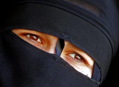 An Iraqi woman waits to vote at a polling station in the Iraqi town of Fallujah Thursday Dec. 15, 2005.