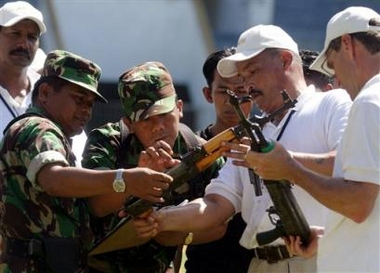 Members of the Aceh Monitoring Mission, right, and Indonesian soldiers, left, inspect weapons, surrendered by the Free Aceh Movement (GAM), to be registered by Indonesian Army before being destroyed in Banda Aceh, Indonesia, Monday, Dec. 19, 2005.