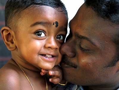 One-year-old tsunami survivor Abilass Jeyarajah, also known as "Baby 81", plays with his father Murugupillai Jeyarajah in Cheddipalaiyam village in Batticaloa, eastern Sri Lanka, in this October 20, 2005 file photo. Nearly 10 months after he was found among debris to become a beacon of hope and tsunami-devastated Sri Lanka's best-known survivor, "Baby 81" celebrated his first birthday on Wednesday with a trip to a Hindu temple. [Reuters]