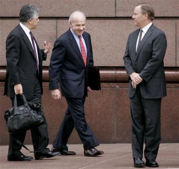 Former Enron CEO Jeffrey Skilling, right, waits to cross the street as Enron founder Kenneth Lay, center, talks with Skilling's lawyer, Daniel Petrocelli, left, as they make their way to the federal courthouse for a pretrial hearing Friday, Dec. 16, 2005 in Houston.