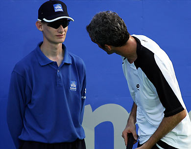 Davide Sanguinetti of Italy (R) stares at a line umpire after unsuccessfully disputing a call during his loss to James Blake of the US at the Sydney International tennis tournament January 9, 2006. Unseeded Blake beat Sanguinetti 7-6 6-4. [Reuters] 