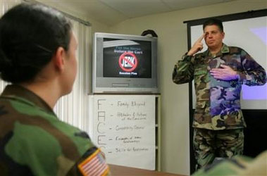 Chaplain Major Jonathan Kegley, right, shows the 'No Jerks' salute to Pvc. Julie Romero, left, and others while speaking to a group of soldiers after teaching a P.I.C.K a Partner class, also called 'How Not to Marry a Jerk,' a program about choosing a spouse wisely, at the Presidio in Monterey, Calif., Friday, Jan. 27, 2006. [AP]