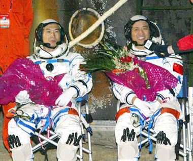 Astronaut Nie Haisheng (R) talks to journalists after he and Fei Junlong got out of the re-entry capsule of the Shenzhou VI spacecaft at the main landing field in Central Inner Mongolia Autonomous Region Monday morning October 17, 2005. The module landed 4:33 A.M. after a five-day flight.