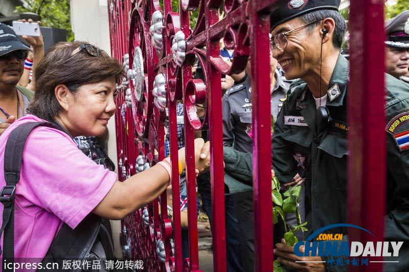 英拉稱不會武力驅(qū)散示威 警民和諧相處互贈花朵