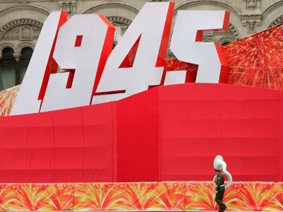 A tuba player of a military band walks past a giant display during a World War II victory ceremony in Red Square in Moscow May 9, 2007. 