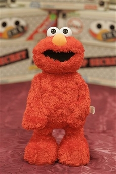 A new T.M.X. ELMO, making its global debut on the tenth anniversary of Tickle Me Elmo, stands on a table at KB Toys at Manhattan Mall in New York, Tuesday, Sept. 19, 2006. He's still red, fuzzy and really ticklish, but now Elmo's laughing fits have him slapping his knee, falling to the floor, rolling over and pounding his arm. Fisher-Price, a unit of Mattel Inc., on Tuesday took the wraps off T.M.X. Elmo, ending months of unprecedented secrecy that's had the toy industry abuzz.