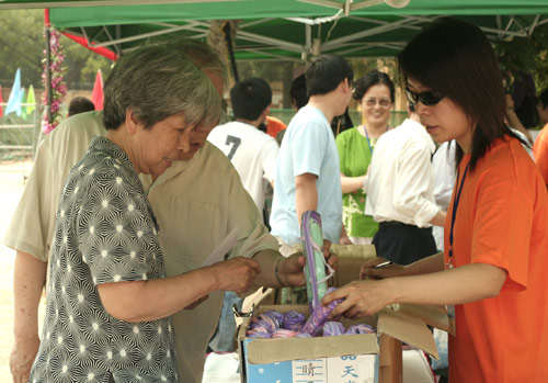 Voters choose the umbrella as a souvenir after voting on demolishment and reconstruction of old buildings in Juixiaqiao Sub-district in Beijing, June 9, 2007. Local government and the real estate developer jointly organize the vote on Saturday to see if majority residents of over 5000 families accept the new compensation policy after failed attempts to reach an agreement through other ways. Both notary officials and supervisors are invited to monitor the vote that runs from 9 a.m. to 9 p.m. at six ballot booths. [Sun Yuqing/www.healinghandsltd.com]