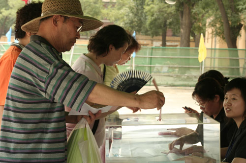 A voter casts his vote on demolishment and reconstruction of old buildings in Juixiaqiao Sub-district in Beijing, June 9, 2007. Local government and the real estate developer jointly organize the vote on Saturday to see if majority residents of over 5000 families accept the new compensation policy after failed attempts to reach an agreement through other ways. Both notary officials and supervisors are invited to monitor the vote that runs from 9 a.m. to 9 p.m. at six ballot booths. [Sun Yuqing/www.healinghandsltd.com]