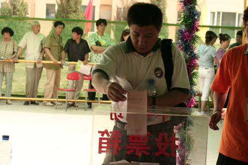 A voter casts his vote on demolishment and reconstruction of old buildings in Juixiaqiao Sub-district in Beijing, June 9, 2007. Local government and the real estate developer jointly organize the vote on Saturday to see if majority residents of over 5000 families accept the new compensation policy after failed attempts to reach an agreement through other ways. Both notary officials and supervisors are invited to monitor the vote that runs from 9 a.m. to 9 p.m. at six ballot booths. [Sun Yuqing/www.healinghandsltd.com]