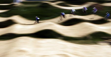 Competitors ride over the course during the UCI BMX Supercross World Cup at Laoshan Bicycle Moto Cross (BMX) venue in Beijing August 21, 2007.[Xinhua]