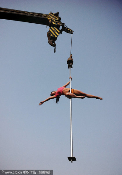 Crane hoists pole dancers in air