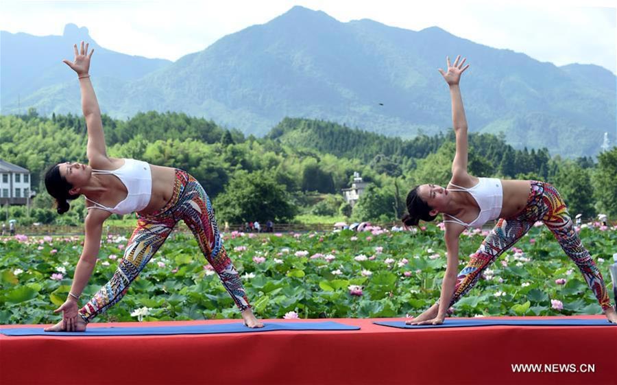 Fans practice yoga at lotus culture park in SE China's Fujian