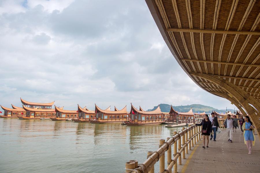 Tourists go sightseeing at Gudian wetland park in Kunming