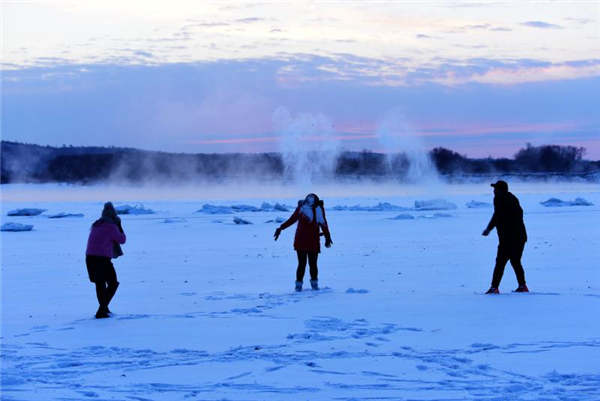 Yoga enthusiasts practice on frozen river in Heilongjiang